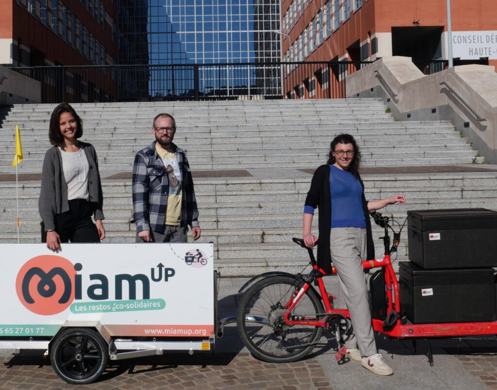 Equipe Miam'Up devant un vélo cargo chargé de dons de repas