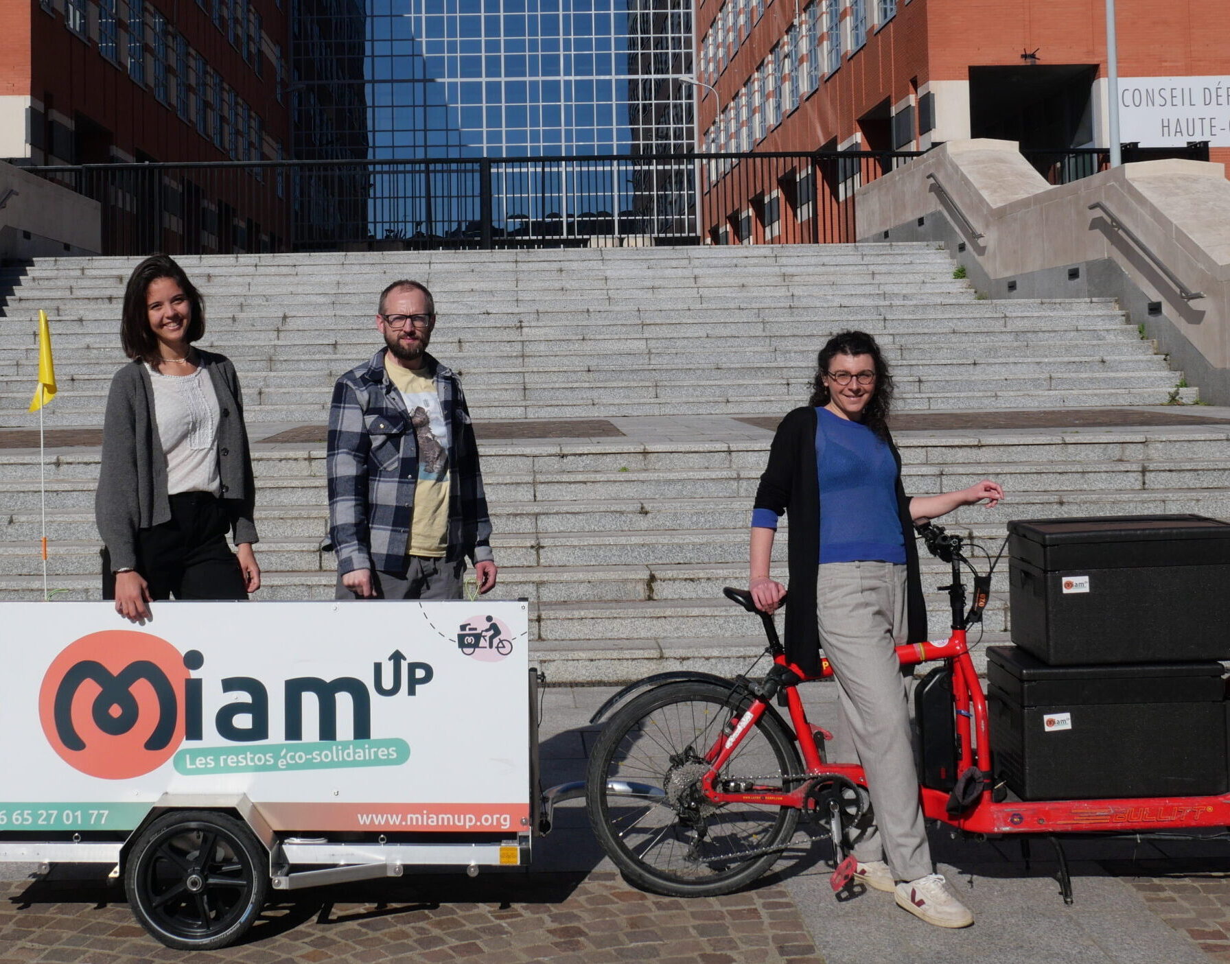 Equipe Miam'Up devant un vélo cargo chargé de dons de repas